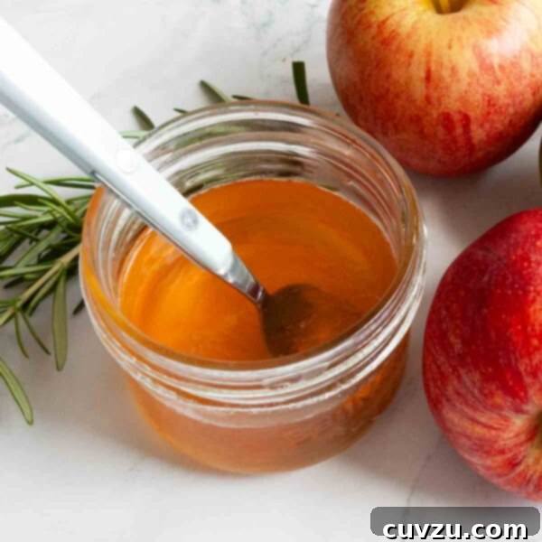Orchard's Golden Jelly 10 A small jar of beautifully set apple jelly with a spoon nestled inside.