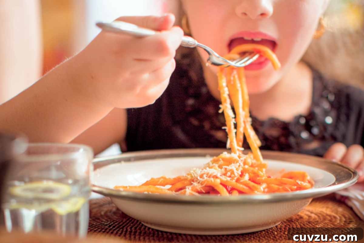 Traditional Italian Tomato Sauce 4 A child eating a bowl of cooked pasta with red sauce.