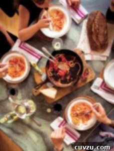 Traditional Italian Tomato Sauce 5 People gathered around a cast-iron skillet on a wooden board with some spaghetti and red sauce.