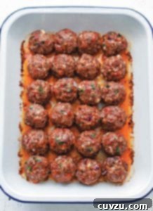White pan of 24 orange-red chorizo golf-ball-size meatballs