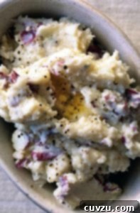 A baking dish filled with mashed potatoes that are sprinkled with black pepper