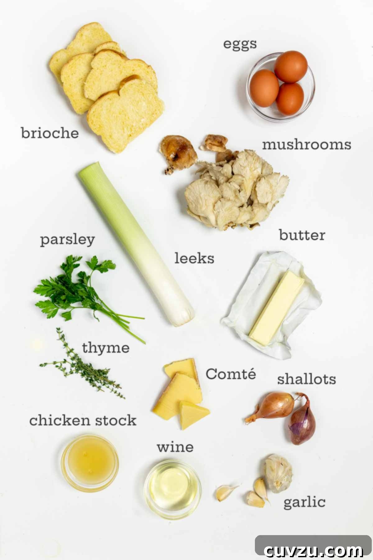 Ingredients for wild mushroom stuffing laid out: bread, various mushrooms, eggs, butter, cheese, fresh herbs, shallots, garlic, chicken stock, and white wine.