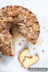 Lush Sour Cream Coffee Cake 4 A whole sour cream coffee cake with a wedge cut from it.
