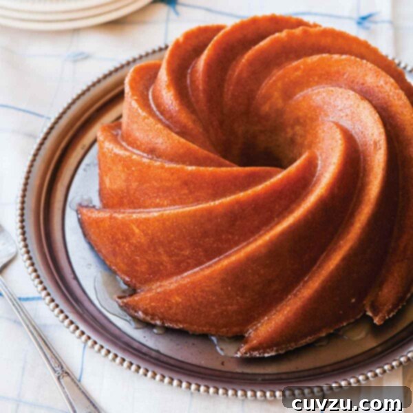 A fancy Bundt Kentucky bourbon cake on a silver platter, showcasing its golden color and elegant shape.