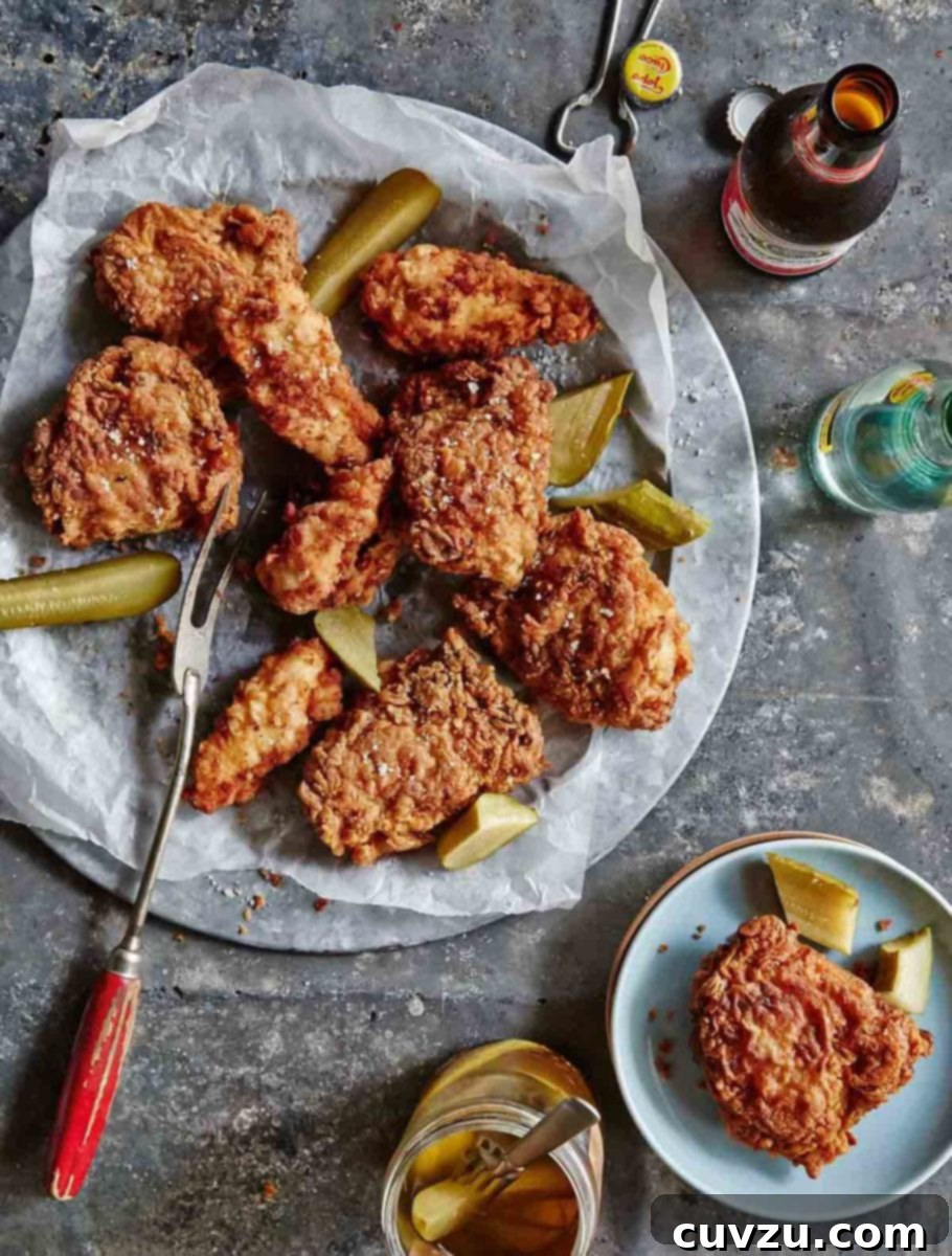 Dill-ightful Fried Chicken 2 A platter of golden-brown pickle-brined fried chicken, garnished with fresh dill pickle slices, alongside a chilled bottle of craft beer.