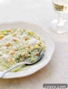 A bowl filled with zucchini risotto and a spoon resting inside.