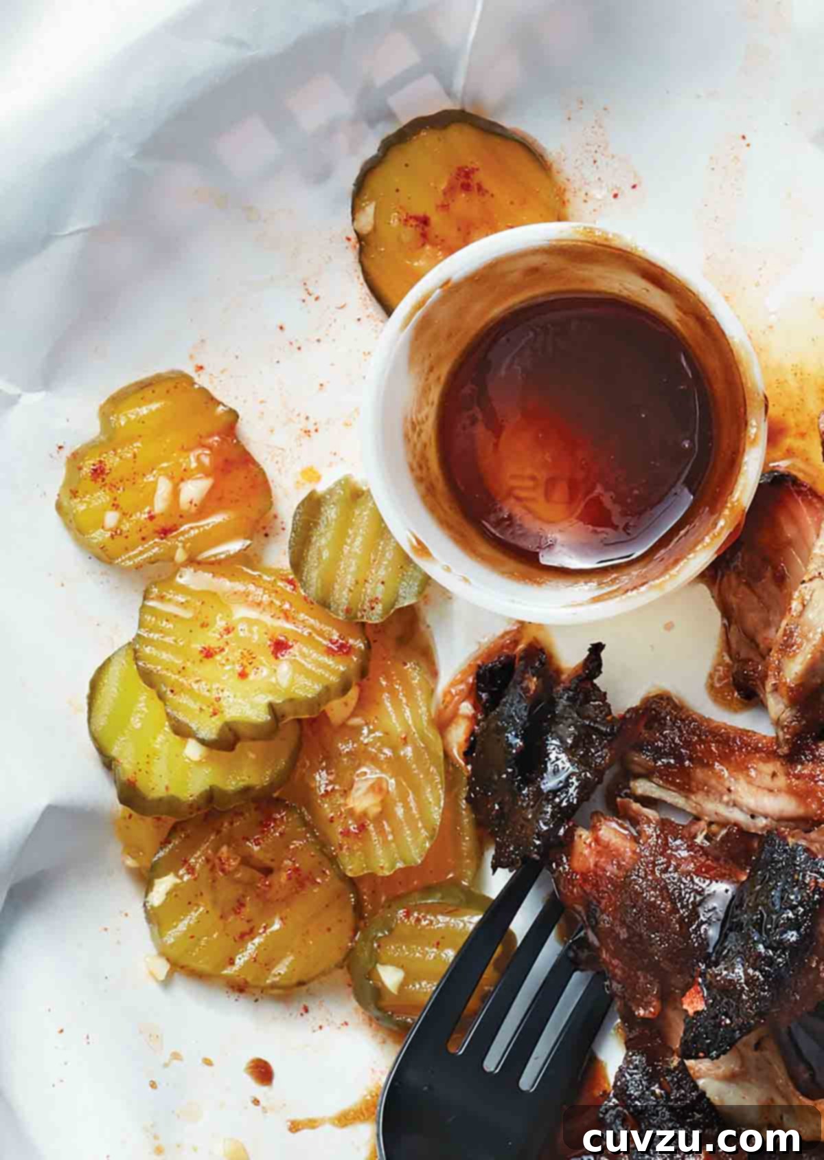 Pitmaster Pickles 3 A generous pile of barbecue pickles served alongside barbecued meat and a fork, ready to be enjoyed.