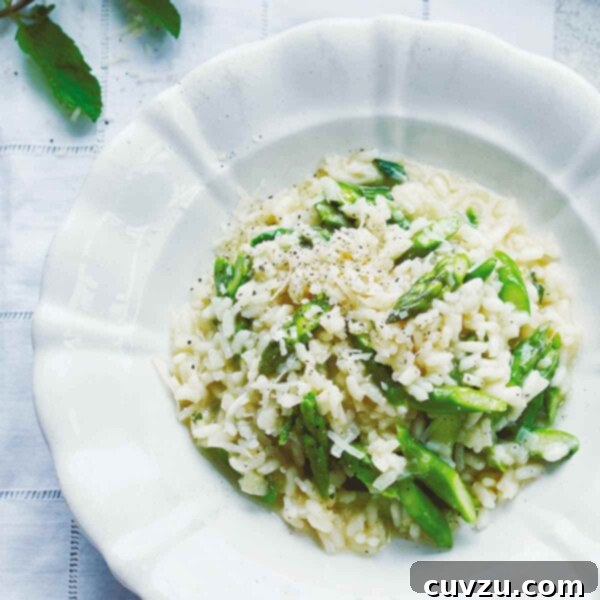 A plate and a bowl of asparagus risotto with a fork resting beside the bowl.