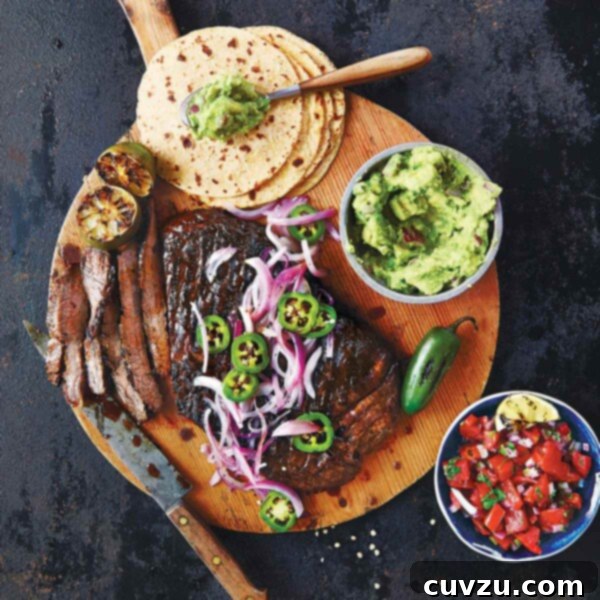 The makings of beef fajitas on a wooden board - tortillas, steak, guacamole, salsa.