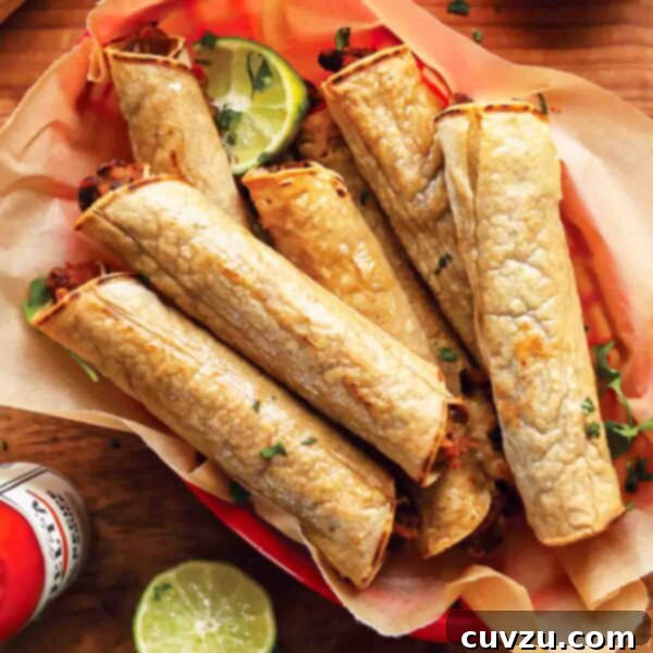 A basket of golden black bean taquitos with fresh lime wedges and a side of hot sauce.