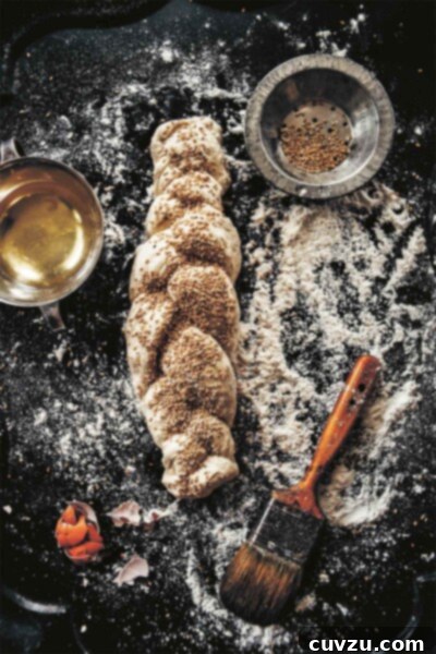 A perfectly baked no-knead Italian bread loaf, adorned with sesame seeds, presented on a dark surface. The image captures the bread's golden-brown crust and inviting texture, ready to be sliced and enjoyed.