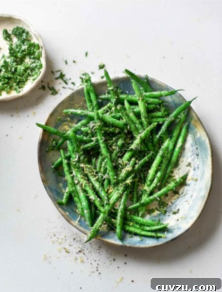 A bowls of green beans gremolata with a small dish of gremolata on the side.