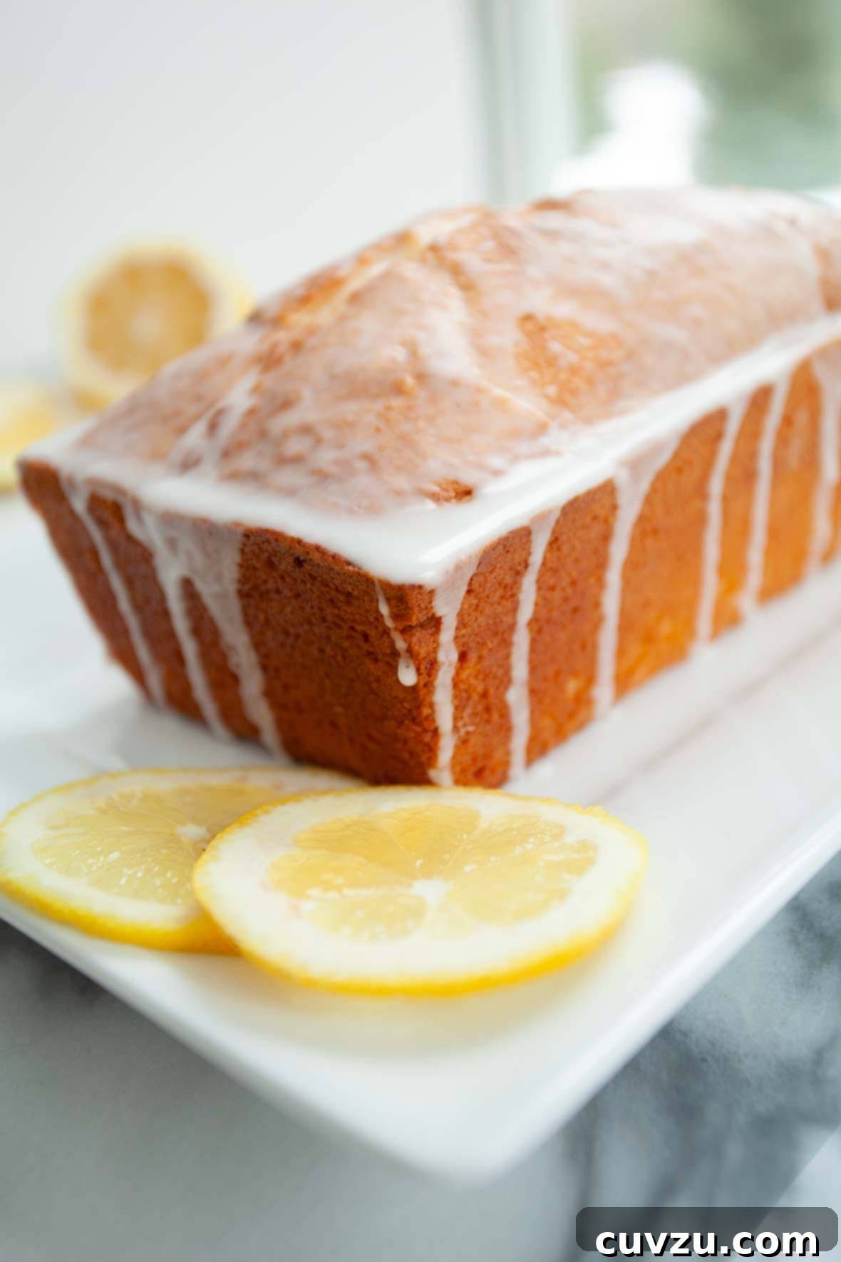 Velvet Cream Cheese Pound Cake 4 A cream cheese pound cake adorned with fresh lemons, highlighting its citrusy notes.