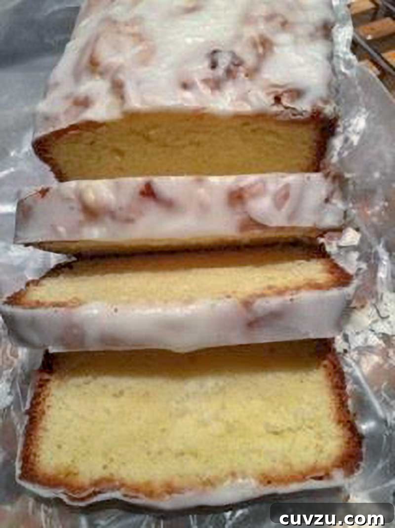Velvet Cream Cheese Pound Cake 7 A beautifully cut vanilla pound cake with a glistening lemon glaze, showing its even slices.