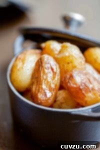 Close-up of braised new potatoes in a cast iron pot.