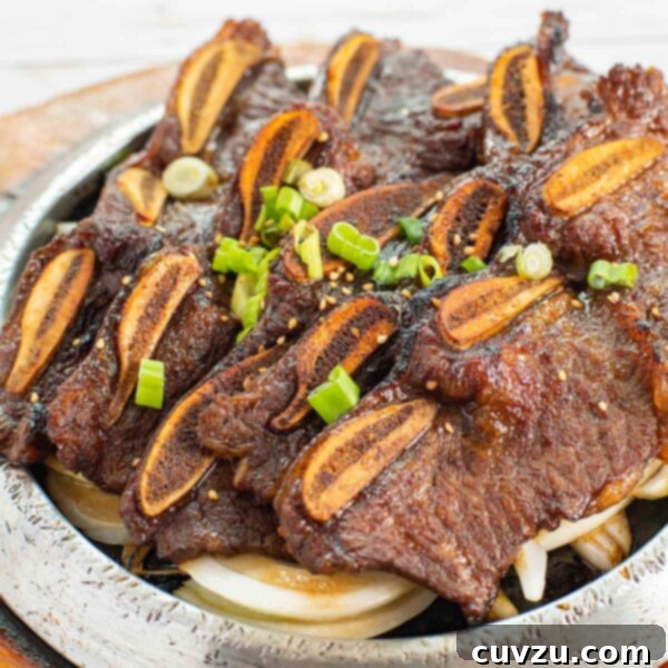 Strips of Korean beef barbecue on a platter, garnished with green onions and sesame seeds.