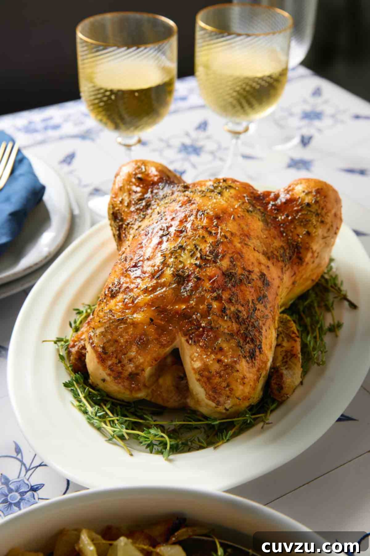 Classic French Roast Chicken 9 A beautifully presented whole French roast chicken, Poulet Rôti, on a serving platter, with a bowl of roasted root vegetables ready to accompany it.