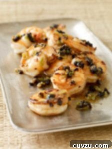 Shrimp with black beans piled on a rectangular metal tray.