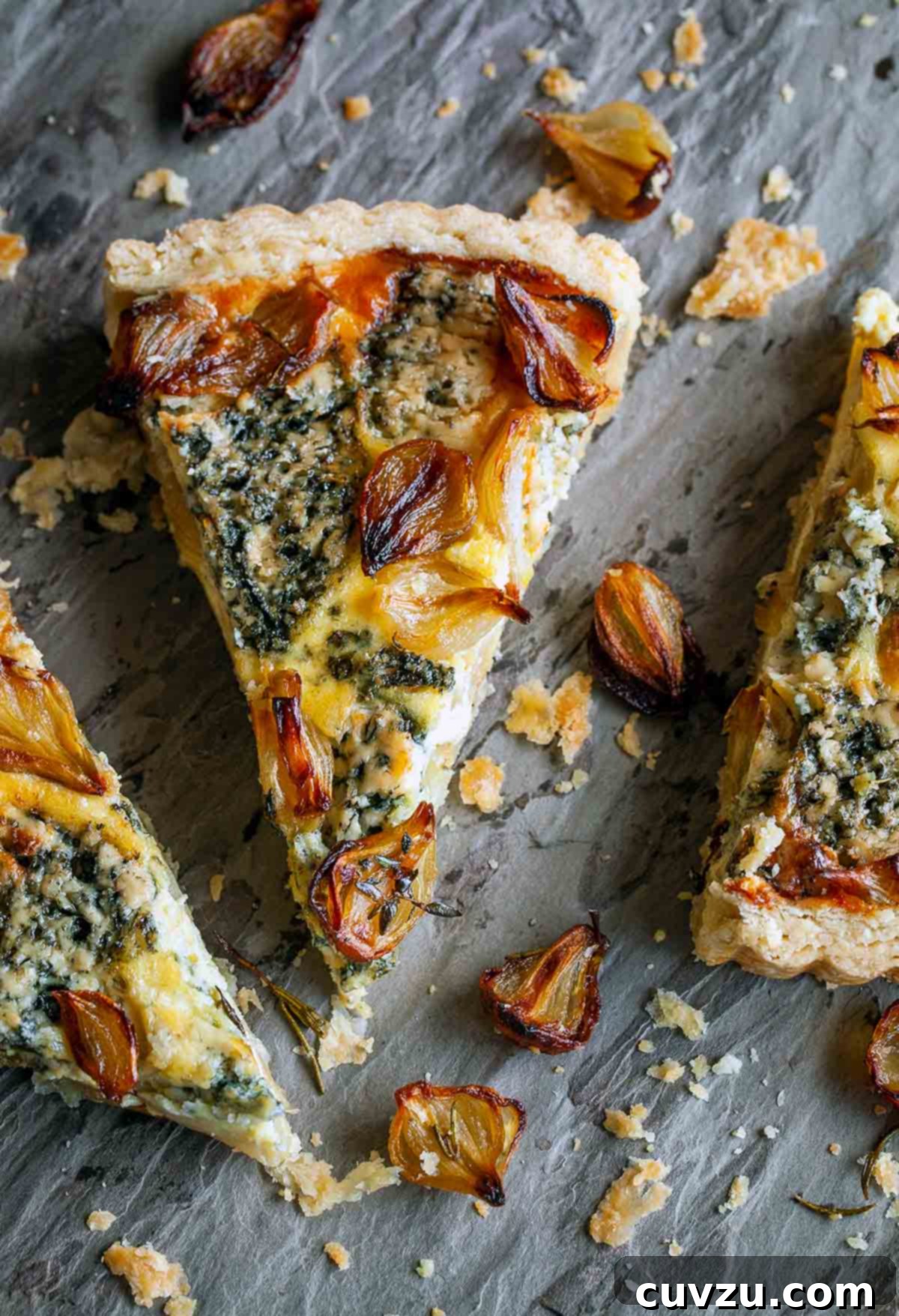 Caramelized Onion and Tangy Blue Cheese Tart 5 An onion and blue cheese tart cut into wedges with crispy onions scattered around it.