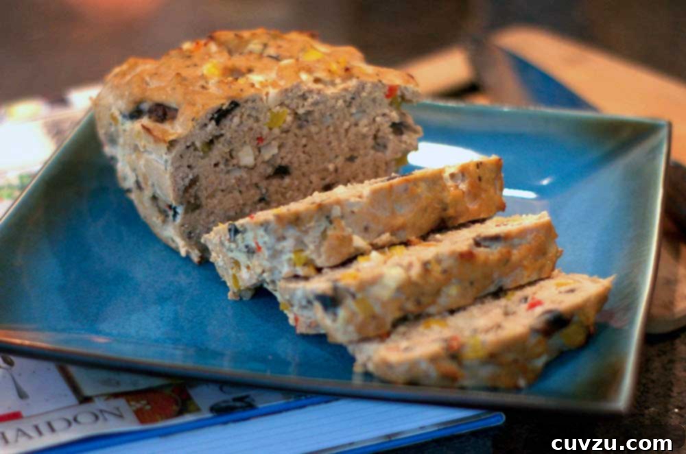 A loaf of turkey meatloaf studded with diced bell peppers, onion, and mushroom, and barbecue sauce