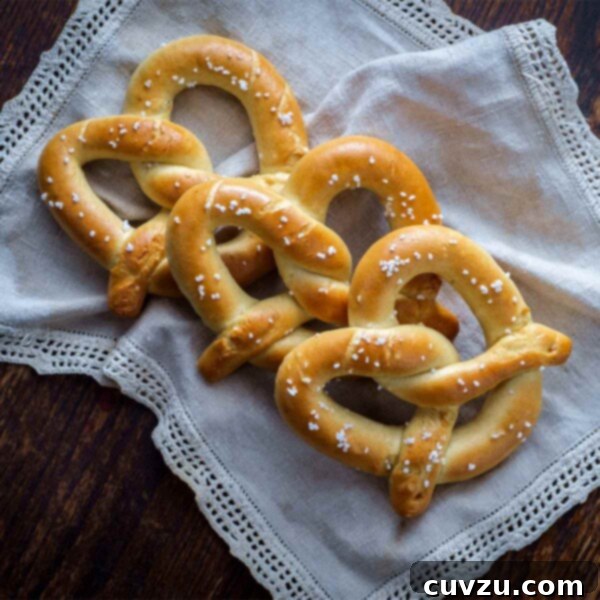 Irresistible Homemade Soft Pretzels 3 Three homemade soft pretzels on a linen cloth.