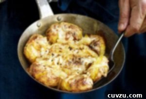 A man with a skillet of Portuguese punched potatoes, caramelized onions, cheese, called batatas a murro in Portuguese