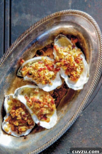 A tray of oysters Rockefeller with bacon—baked oysters topped with bread crumbs, bacon, and butter.