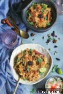 Two bowls filled with chicken biriyani on a blue cloth