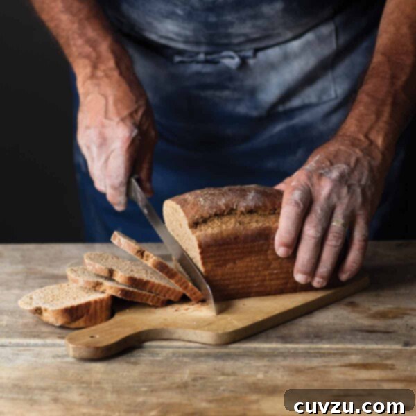A rustic loaf of milk rye bread, partially sliced on a cutting board.