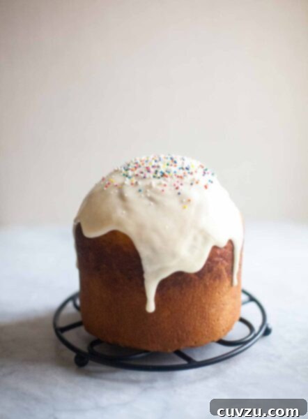 Easter Kulich 3 A loaf of kulich topped with glaze and sprinkles on a round trivet