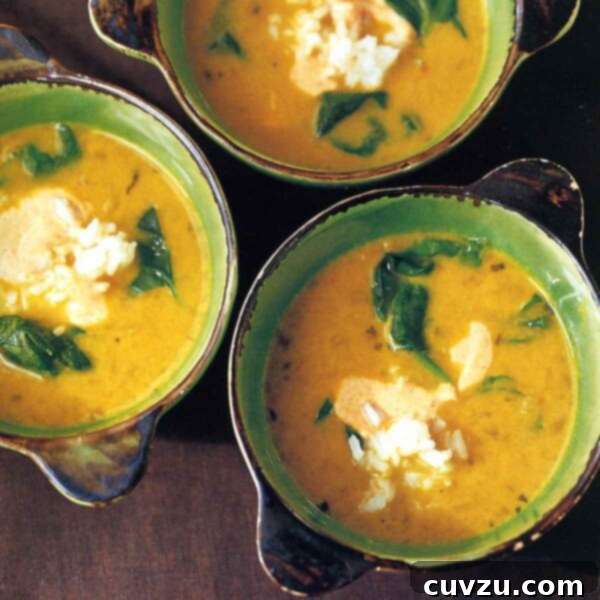 Tropical Golden Pea Coconut Soup 3 A vibrant close-up of Yellow Pea and Coconut Milk Soup, showcasing three bowls filled with the rich, golden broth, flecks of green spinach, and fluffy white rice, topped with a creamy swirl of spiced yogurt.