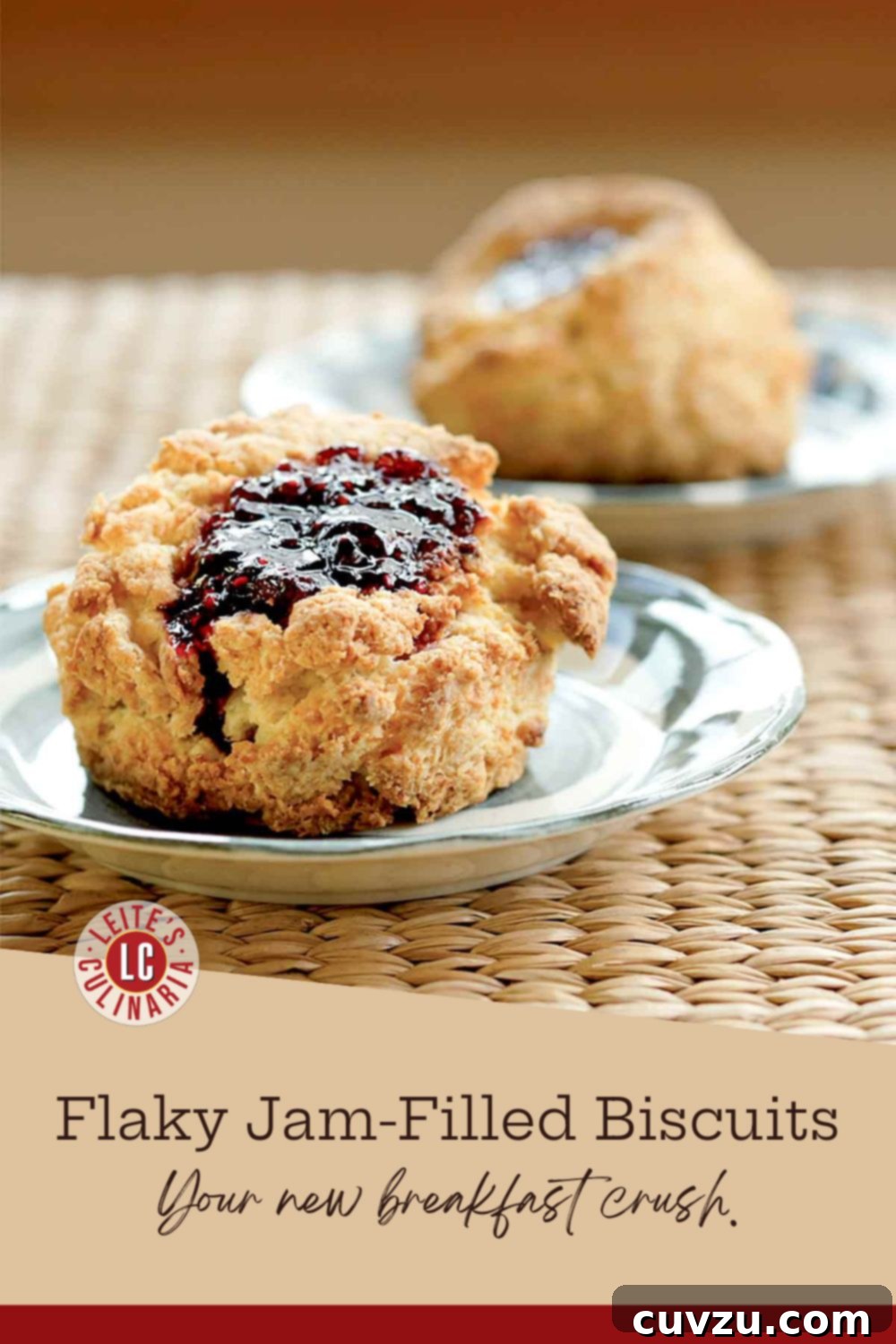 Grand Central Bakery Sweet Orchard Bites 3 A golden-brown buttermilk biscuit filled with vibrant jam on a white plate, set on a woven mat. The jam drips down the sides.