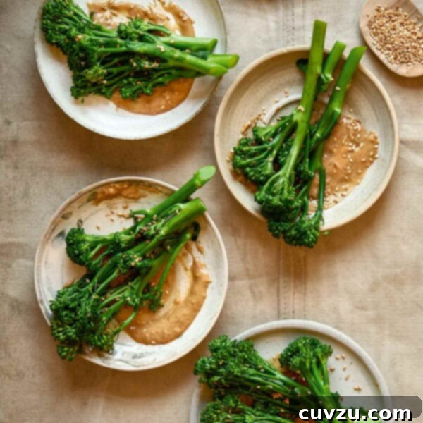Peanut-Glazed Broccoli 3 Four plates topped with broccoli with peanut sauce and a small dish of sesame seeds on the side.