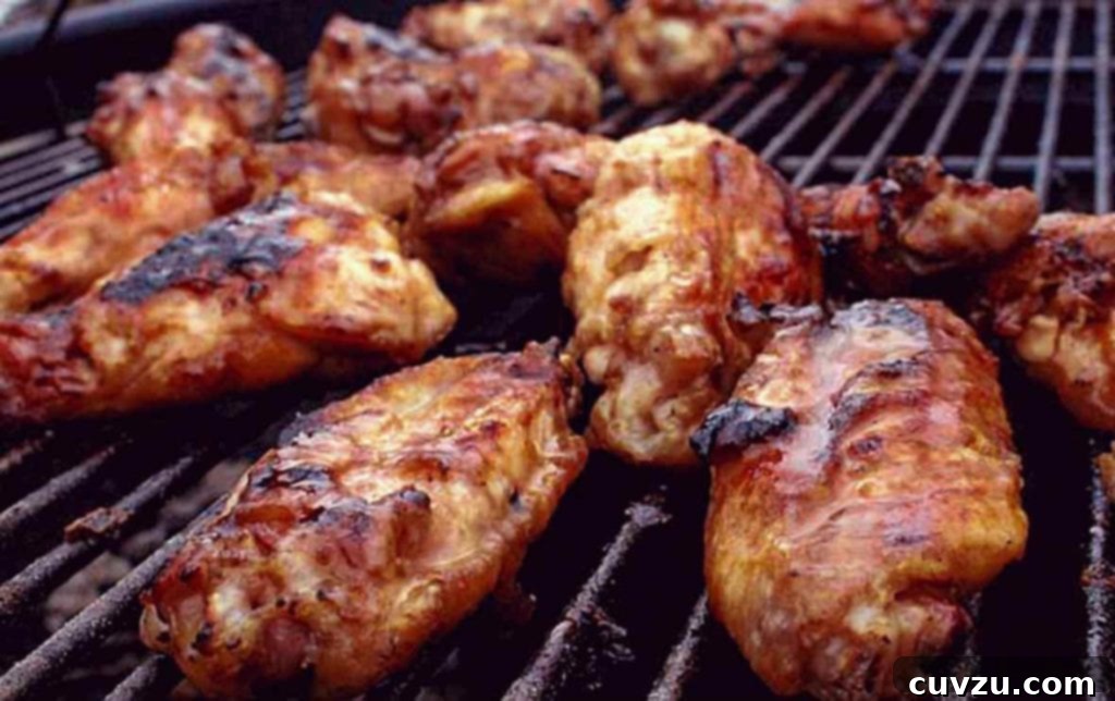 Smoky Maple Bourbon Wings 5 Grilled chicken wings with maple bourbon sauce resting on a grill grate.