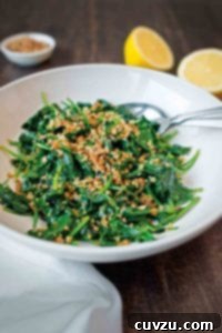 Garlicky Spinach with Toasted Crumbs 3 A white serving bowl filled with sauteed spinach and bread crumbs.
