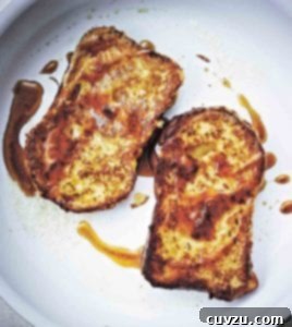 Two slices of French toast, fried until golden and drizzled with maple syrup.