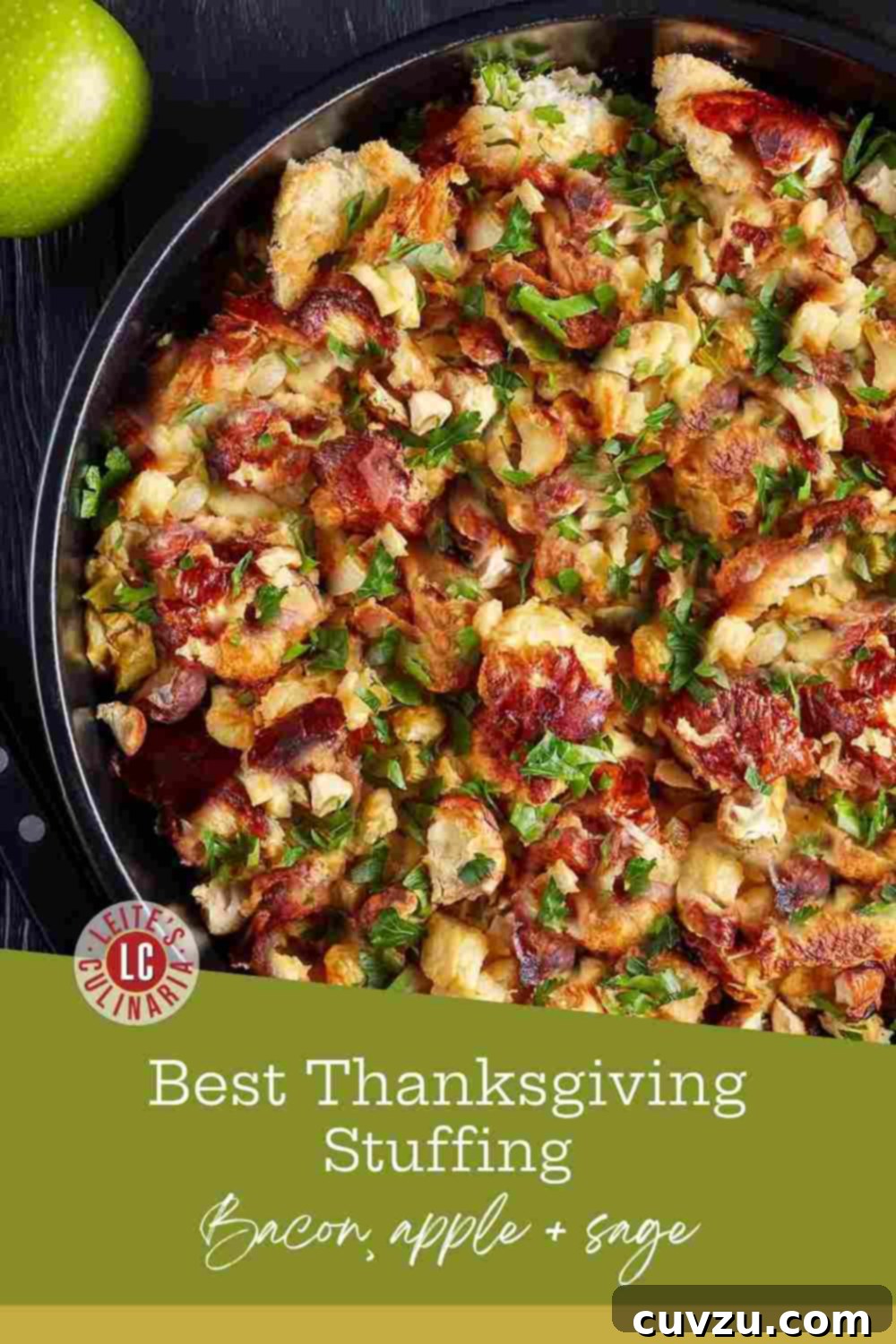 Smoky Bacon, Apple, and Sweet Onion Stuffing 3 A black bowl brimming with gourmet holiday stuffing, featuring rustic bread cubes, aromatic fresh sage leaves, irresistible crispy bacon pieces, and finely diced apples, ready for a festive meal.