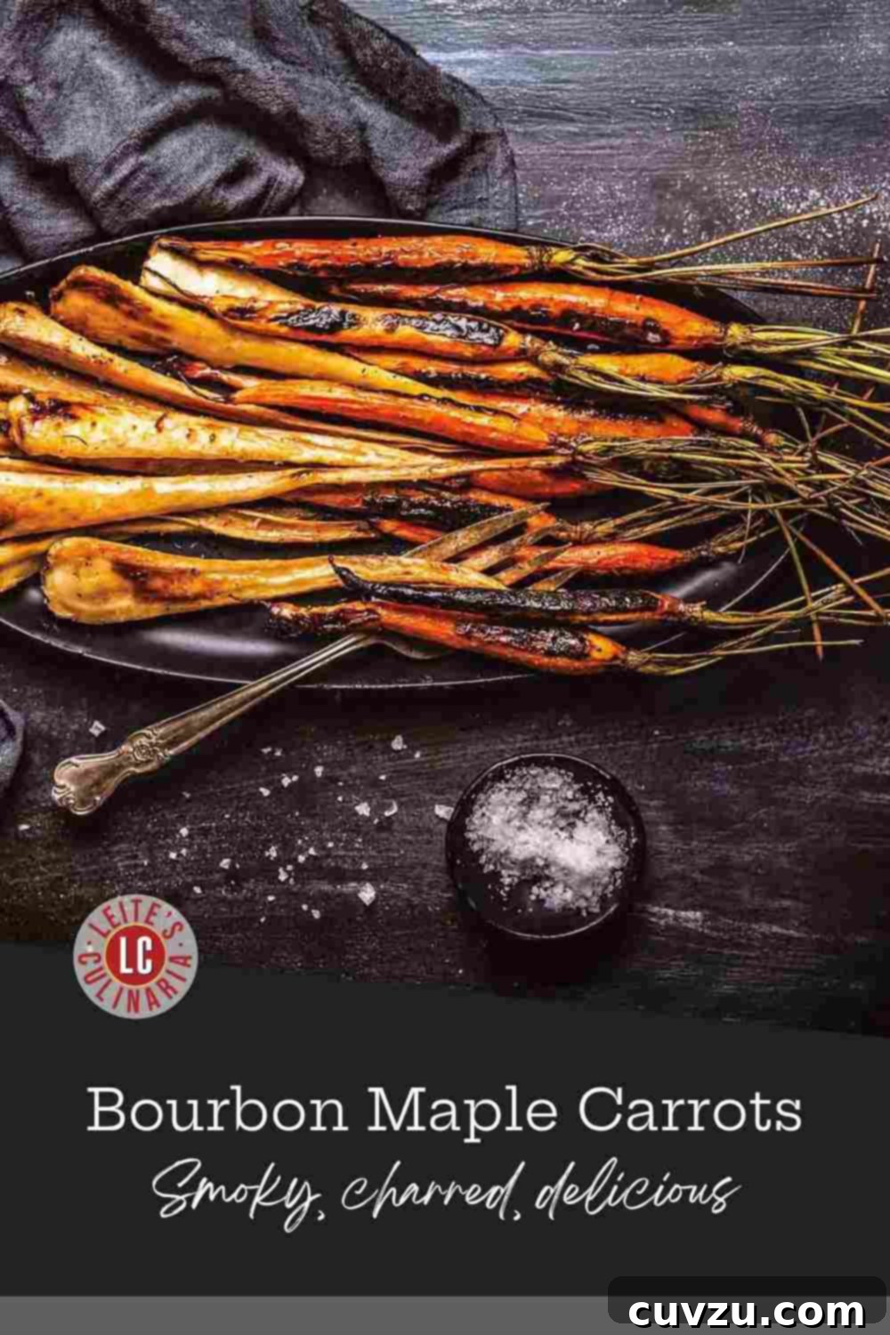 Sticky Bourbon Maple Carrots 3 Close-up of radiant roasted carrots and parsnips, piled high and shimmering with a maple-bourbon glaze on a dark oval platter.