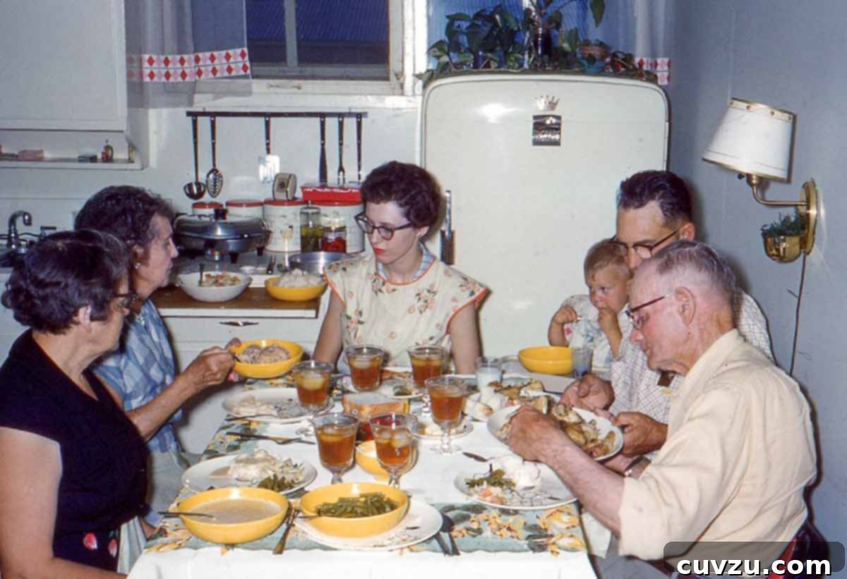 A family at dinner in a kitchen, from the 1960s