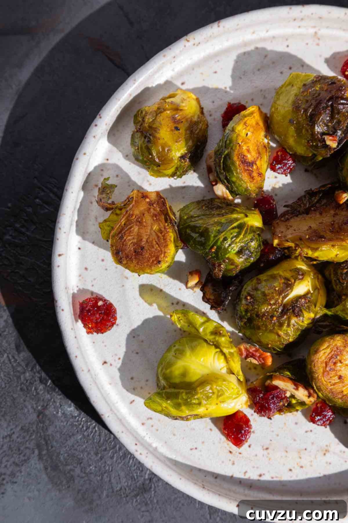 Kickin' Crispy Brussels 7 A plate of spicy roasted Brussels sprouts with cranberries and pecans, ready to be served.