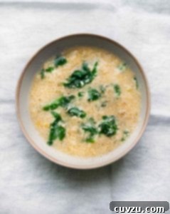 Italian Stracciatella Egg Drop Soup 3 A bowl of Italian rag soup with wilted spinach on a white linen cloth.