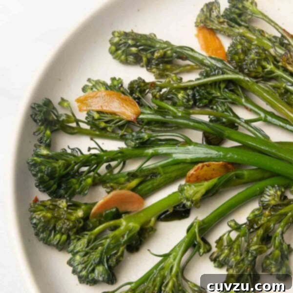 Blistered Skillet Broccolini 10 Seared broccolini and slices of browned garlic on a plate.
