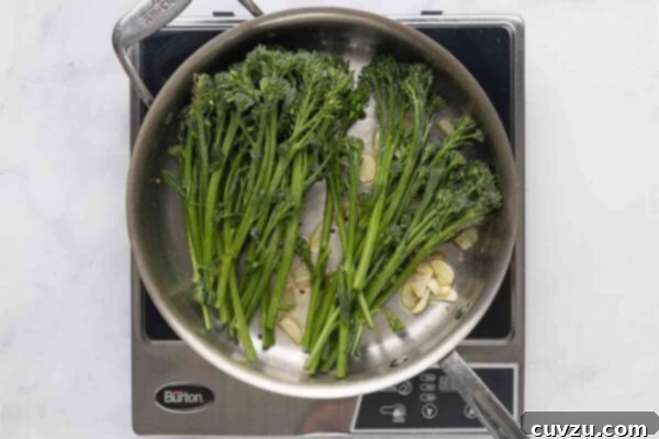 Blistered Skillet Broccolini 13 Broccolini and garlic slices in a metal skillet.