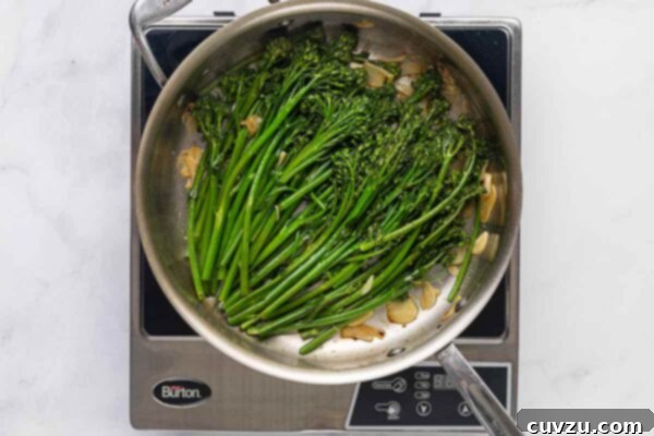 Blistered Skillet Broccolini 15 Broccolini and garlic slices in a metal skillet.