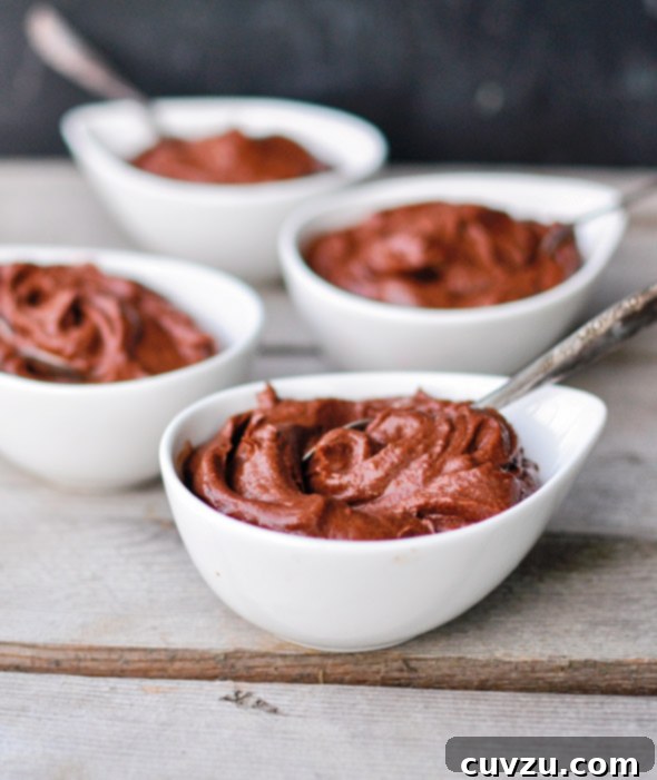 Natural vs. Dutch Process Cocoa Powder: Which One for Your Baking 6 Four individual white bowls of avocado chocolate pudding with spoons on a wooden table, a dessert where cocoa type is less critical for leavening.
