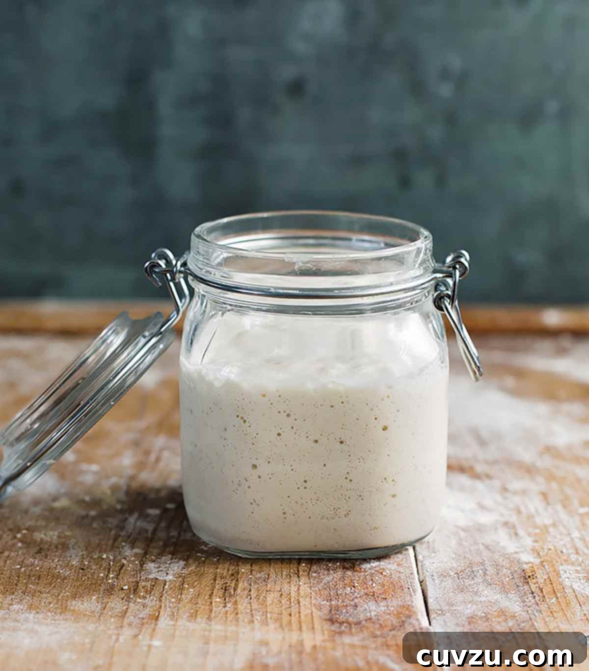 Crafting Your Sourdough Magic 6 A glass jar with a vigorously growing sourdough starter, showing significant rise and bubbles, over several days of feeding.