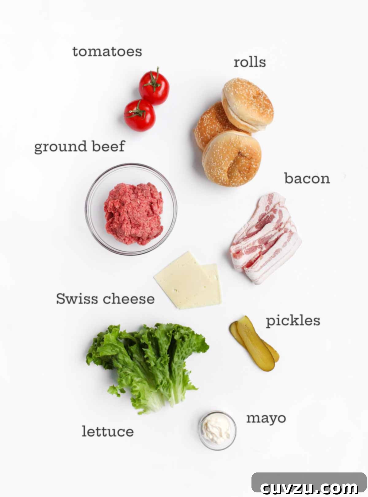 Ultimate Bacon Swiss Burger 3 Essential ingredients laid out for a Bacon Swiss burger, including ground beef, soft buns, Swiss cheese, crispy bacon, fresh tomatoes, crunchy pickles, vibrant lettuce, and creamy mayonnaise.