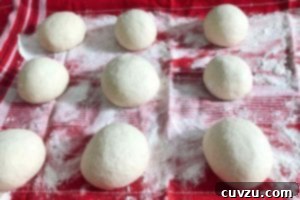 Papo Secos Portuguese Rolls 8 Nine balls of dough rising gently on a towel-lined baking sheet, preparing for the next stage of shaping Papo Secos.