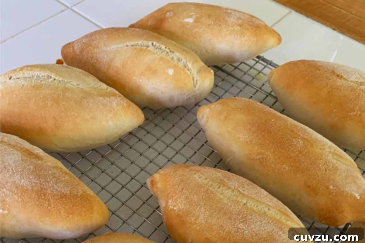Papo Secos Portuguese Rolls 15 Several golden-brown Papo Secos cooling on a wire rack, freshly baked and exhibiting their classic crust.