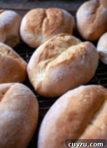 Several cooked Papo Secos on a wire rack, showcasing a golden crust and soft interior.